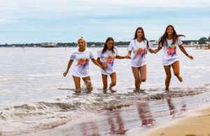 ragazze che corrono sulla riva del mare durante un campo estivo